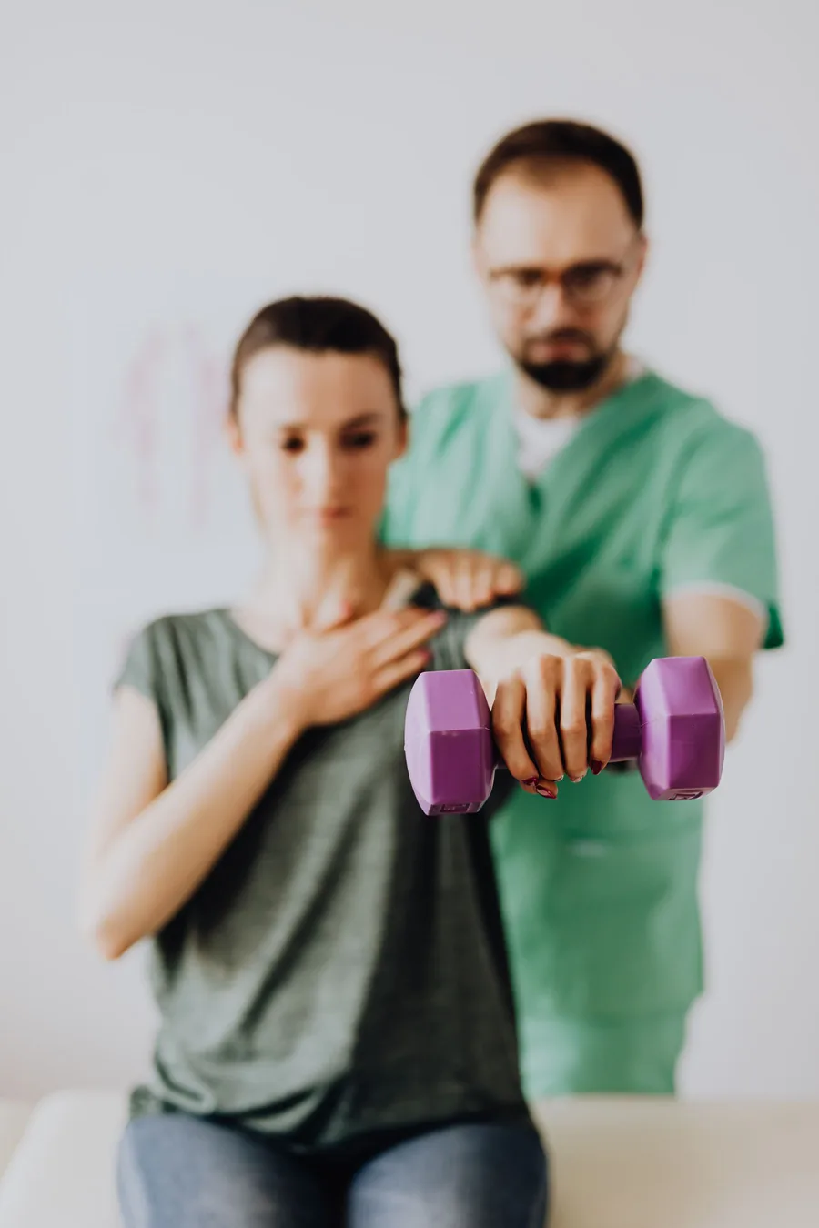 Fisioterapeuta orientando exercício com halter em consultório